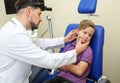 Male otolaryngologist examining little child