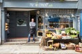 Male Owner Standing Next To Produce Display At Deli