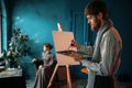 Male painter paints womans portrait