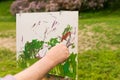Male painter's hand painting a sketch of picture outdoors Royalty Free Stock Photo