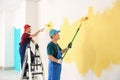 Male painters in uniform working indoors