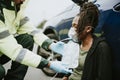 Male paramedic putting on an oxygen mask to an injured woman on a road Royalty Free Stock Photo