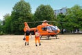 Male paramedics go to modern Red medical helicopter, emergency aircraft Germany on helipad, Air medical services, Rapid Response