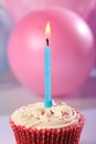 Male party cup cake with blue candle burning