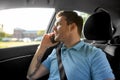 Male passenger calling on smartphone in taxi car