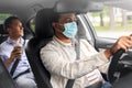 male passenger with coffee and car driver in mask Royalty Free Stock Photo