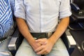 Male passenger with seat belt fastened while sitting on airplane for safe flight.