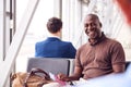 Male Passenger Sitting In Airport Departure Lounge Holding Passport Royalty Free Stock Photo