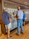 Male passengers in line to inquire and purchase shore excursions from the crew of a Holland America Line cruise ship