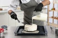 Male pastry chef preparing cake at table in kitchen Royalty Free Stock Photo