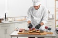 Male pastry chef preparing desserts at table