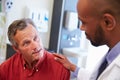 Male Patient Being Reassured By Doctor In Hospital Room