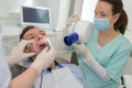 male patient and dentist with assistant during check up