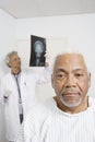 Male Patient With Doctor Examining X-Ray In Background Royalty Free Stock Photo