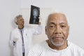 Male Patient With Doctor Examining X-Ray In Background Royalty Free Stock Photo