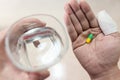 Male patient have capsule pill in hand with water from glass and thumb fingers with injured bandage taking antibiotics,preventing Royalty Free Stock Photo