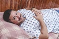 A male patient in his late 30s wearing a gown and lying comfortably in a ward of a hospital Royalty Free Stock Photo