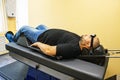 Male patient on treatment of intervertebral discs and spinal hernia, stretching spine on special medical machine tool