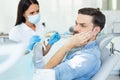 Male patient is upset of pain in dentist office