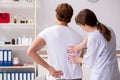 The male patient visiting young female doctor chiropractor Royalty Free Stock Photo