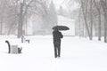 Male pedestrian hiding from the snow under umbrella Royalty Free Stock Photo