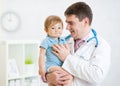 Male pediatrician holding baby boy patient Royalty Free Stock Photo