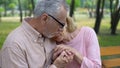 Male pensioner holding sad wife hands, health problem, spouse support, care