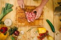 Male person cuts raw meat into slices, top view Royalty Free Stock Photo