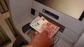 Male person draws money from the cash machine