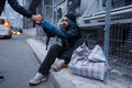 Male person gives cup of hot coffee to homeless Royalty Free Stock Photo