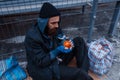 Male person gives food to bearded dirty beggar