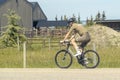 A male person riding a bicycle during summer time