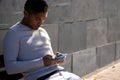 Male person sitting on a bench looking at his mobile phone Royalty Free Stock Photo