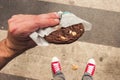 Male person standing on the street with fresh Chocolate Cookie in his hand. First person POV. Top view Royalty Free Stock Photo
