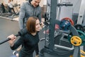 Male personal fitness trainer helping young woman to do workout in gym. Sport, athlete, training, healthy lifestyle and people Royalty Free Stock Photo