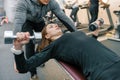 Male personal fitness trainer helping young woman to do workout in gym. Sport, athlete, training, healthy lifestyle and people Royalty Free Stock Photo