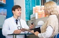 Male pharmaceutist taking patients blood pressure Royalty Free Stock Photo