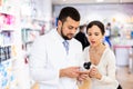 Pharmacist consulting woman buyer about drug