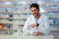 Male pharmacist dispensing medicine holding a box of ta