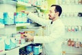 Male pharmacist looking for right medicine in pharmacy Royalty Free Stock Photo