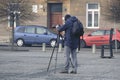 A male photographer in a European city with a professional camera takes a video or photo against the background of house and