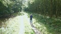 Man walking on a forest road taking pictures