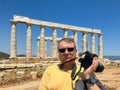 A male photographer with a professional camera at Cape Sounion near the Ruins of the ancient Greek temple of Poseidon Royalty Free Stock Photo