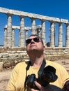 A male photographer with a professional camera at Cape Sounion near the Ruins of the ancient Greek temple of Poseidon Royalty Free Stock Photo