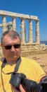 A male photographer with a professional camera at Cape Sounion near the Ruins of the ancient Greek temple of Poseidon Royalty Free Stock Photo