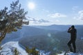 A male photographer takes a beautiful view of the mountains with a camera. Winter and autumn nature of Siberia, travel Royalty Free Stock Photo