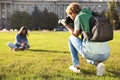 Male photographer taking photo of young woman with professional camera