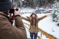 Male photographer taking pictures of happy woman in winter forest Royalty Free Stock Photo