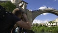 Male photographer waiting for a Bosnian diver to jump into the Neretva River from the Stari Most, old Mostar Bridgeof, Bosnia Royalty Free Stock Photo