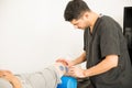 Male Physical Therapist Placing Electrodes On Man`s Knee
